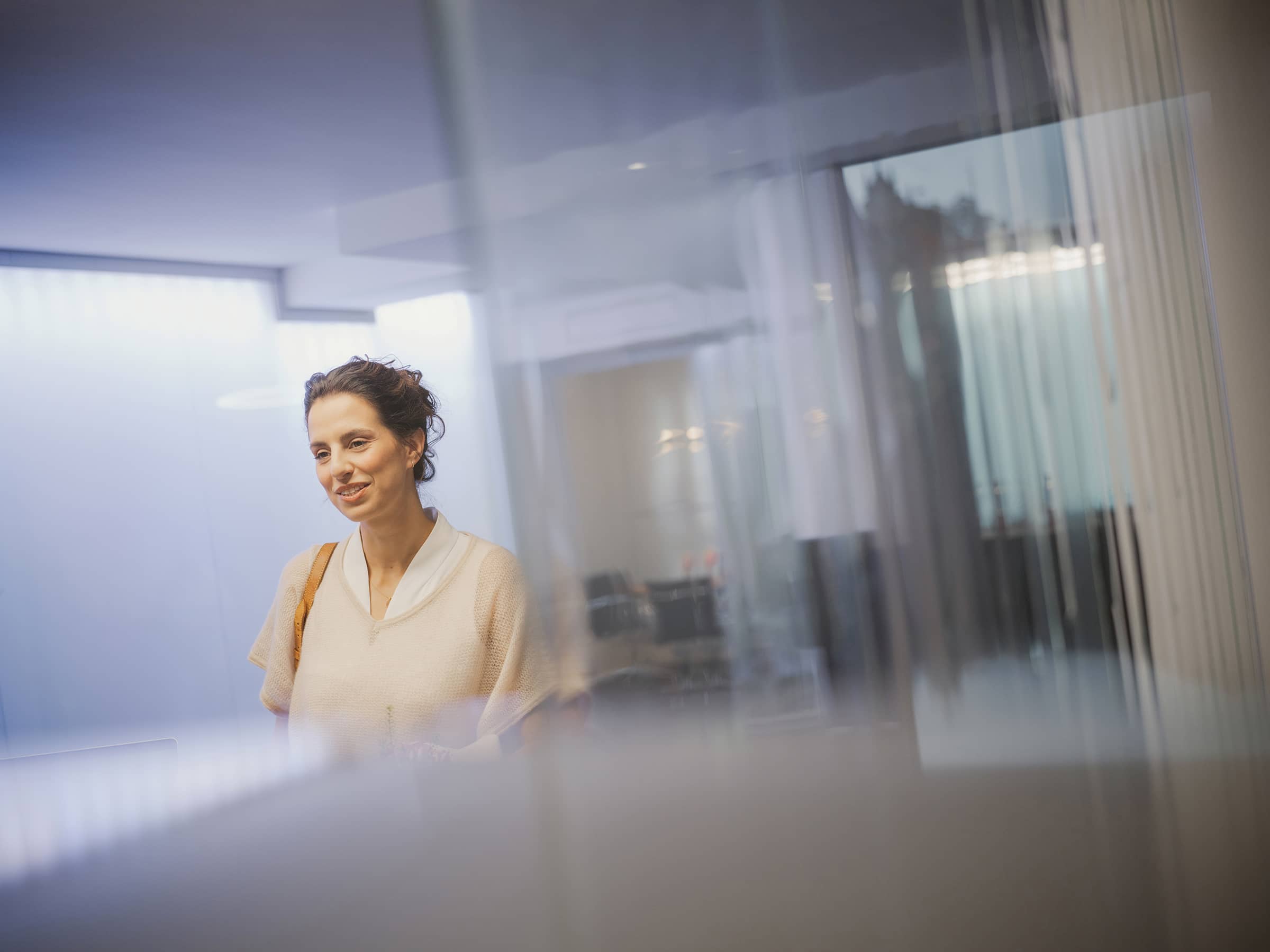 Unsichtbare Aligner im Alltag: Patientin betritt entspannt die Praxis – ihre transparente Zahnspange bleibt nahezu unsichtbar.