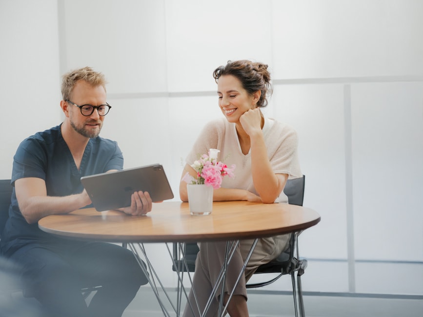 Beratung zu unsichtbaren Alignern: Zahnärztliche Aufklärung mit digitaler Simulation – die Patientin sieht auf dem Tablet, wie die nahezu unsichtbare Zahnkorrektur ihren Alltag erleichtert.