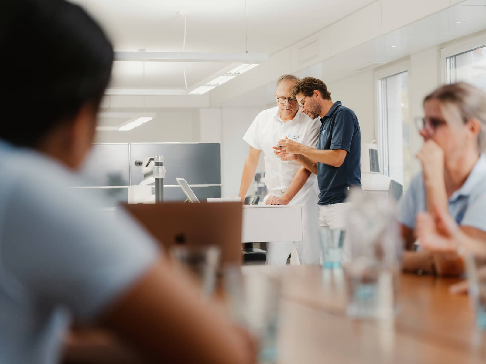Zahnärzte-Team der Q-Zahnärzte Freiburg bespricht Behandlungsplanung für eine präzise und schonende Wurzelbehandlung