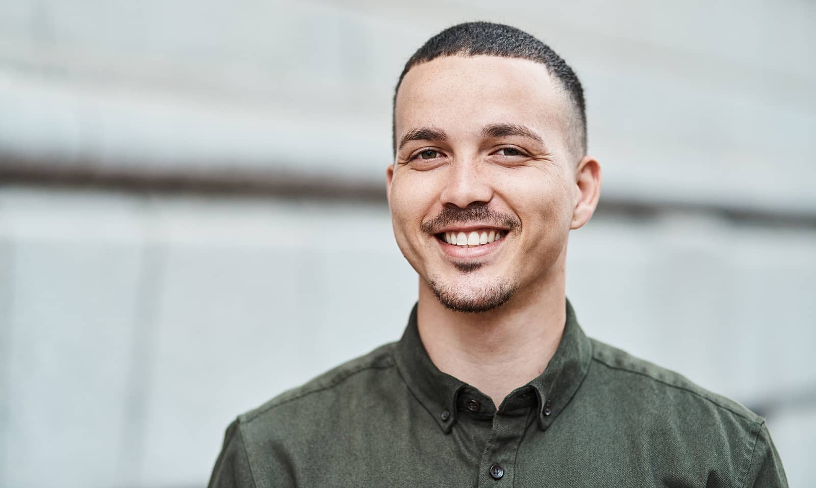 Mann mit gesundem, entspanntem Lächeln nach erfolgreicher Wurzelbehandlung bei Q-Zahnärzte Freiburg