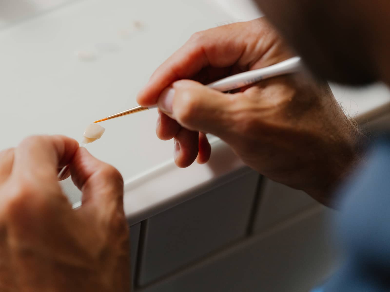 Feinbearbeitung einer Keramikkrone per Hand im Praxislabor der Q-Zahnärzte Freiburg – präziser CEREC-Zahnersatz in höchster Qualität