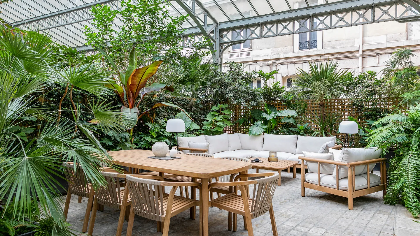Canapé et table sous verdure chez Keeze, parfaits pour un afterwork ou un lieu pour événement à Paris.