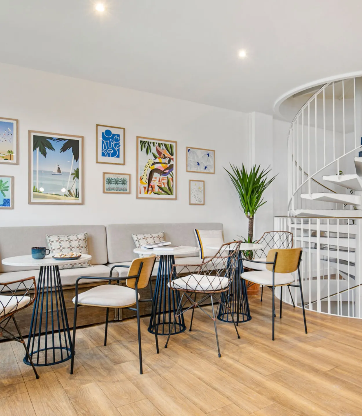 Tables et canapé à côté d’un escalier chez Keeze Courcelles, idéals pour une réunion ou un afterwork à Paris 17e.