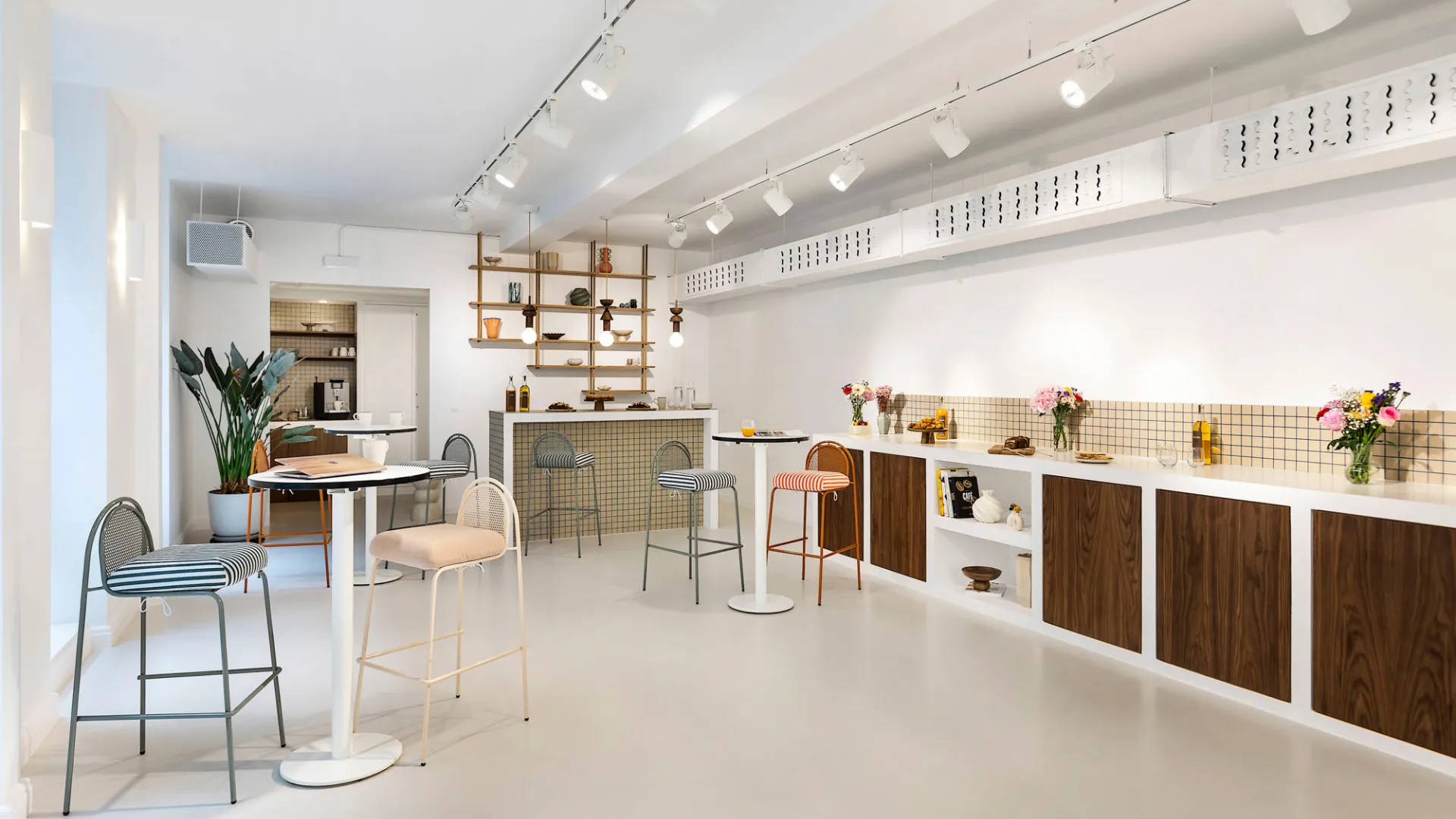 Bar avec tabourets hauts et étagères en bois chez Keeze Bachaumont Bourse à Paris.