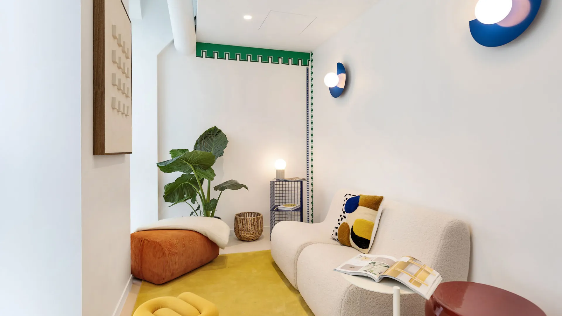 Coin salon intimiste avec tapis jaune et fauteuil en bouclette chez Keeze Bachaumont Bourse à Paris.