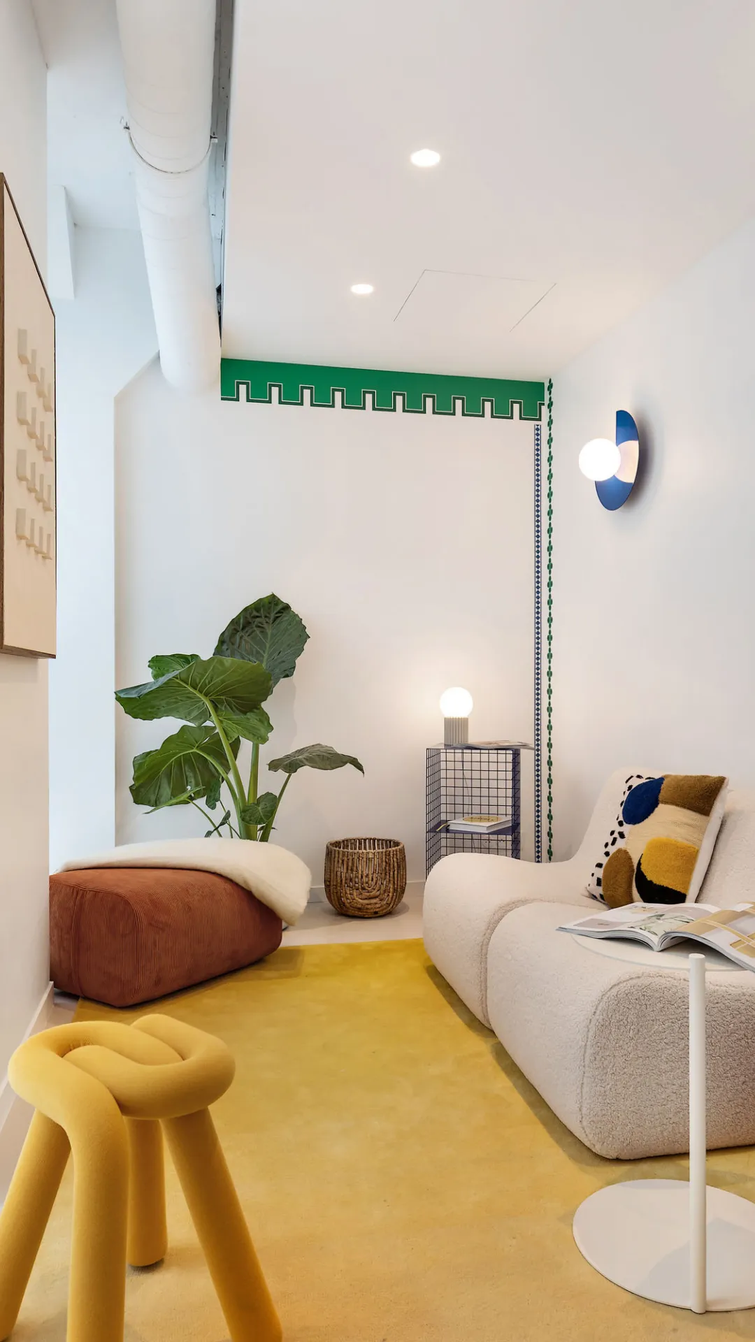 Coin salon intimiste avec tapis jaune et fauteuil en bouclette chez Keeze Bachaumont Bourse à Paris.