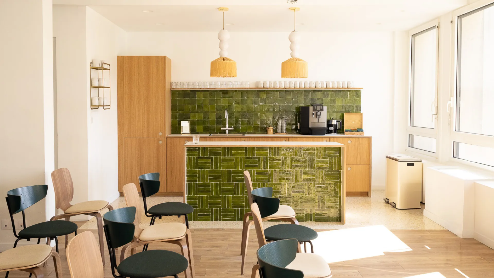 Bar en zellige vert et chaises noires chez Keeze La Volière à Paris.