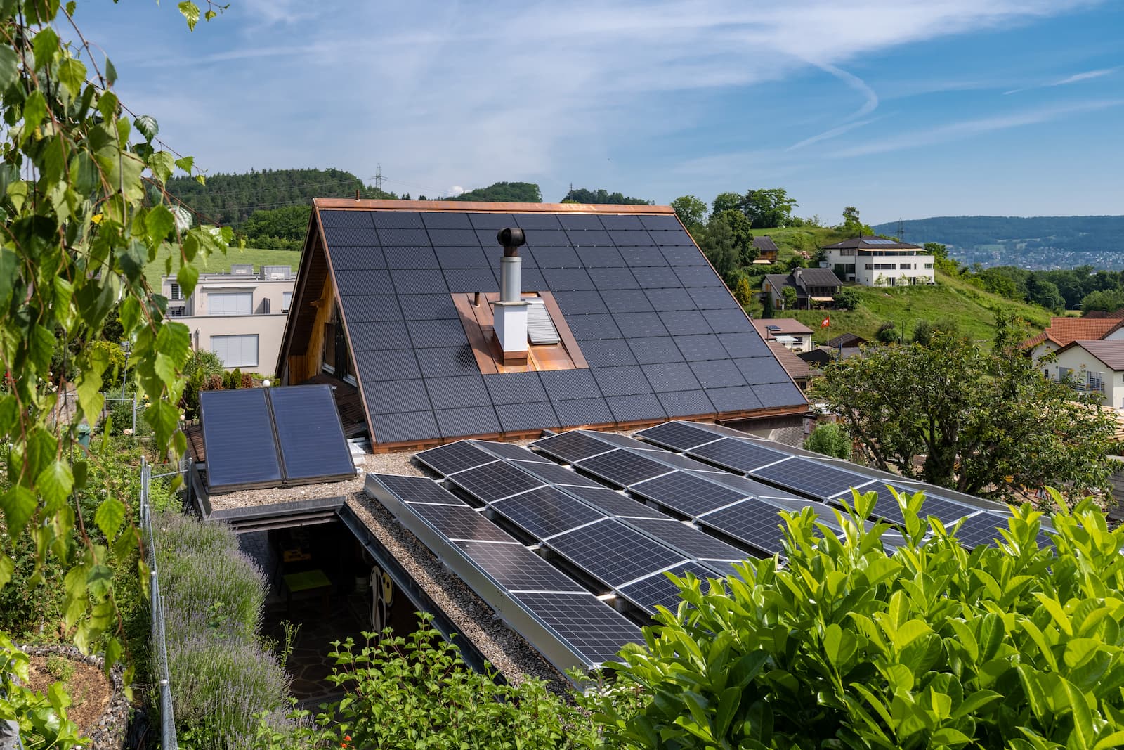 Moderne Solaranlage auf dem Dach eines Einfamilienhauses mit Holzverkleidung, effiziente Energiegewinnung von Vögeli Holzbau AG.