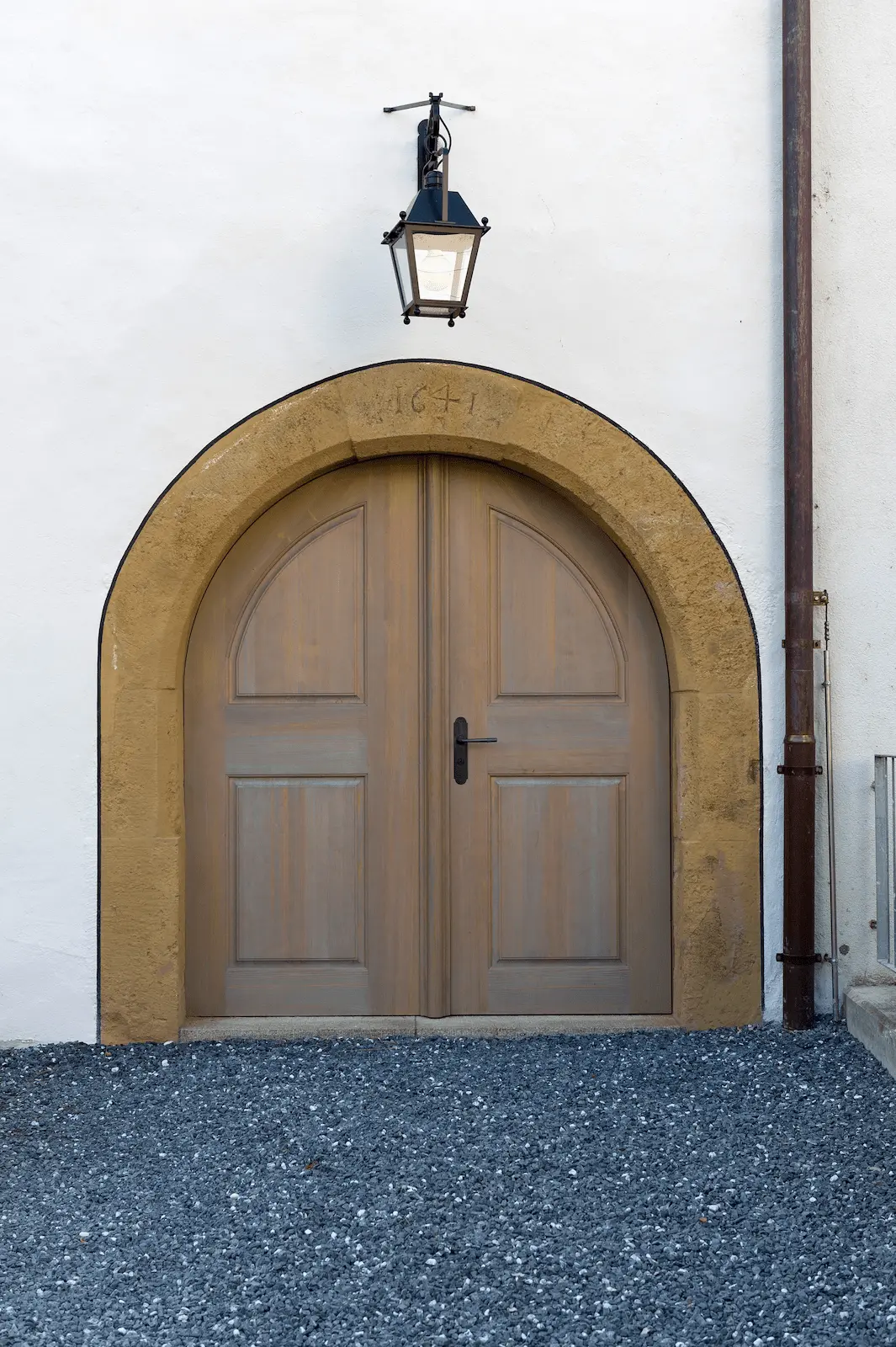 Innenliegendes Rundbogentor aus Holz mit Eisenbeschlägen im historischen Bauwerk in Klingnau