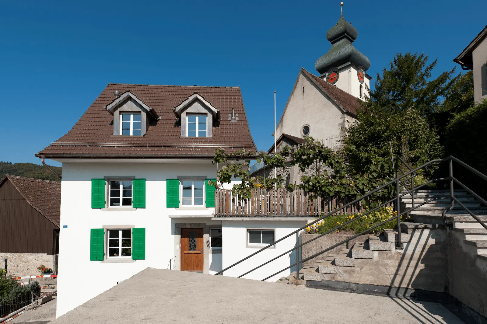 Fassadenansicht der Dachsanierung des Gebäudes in Würenlos mit Ziegeldach und Dachgauben