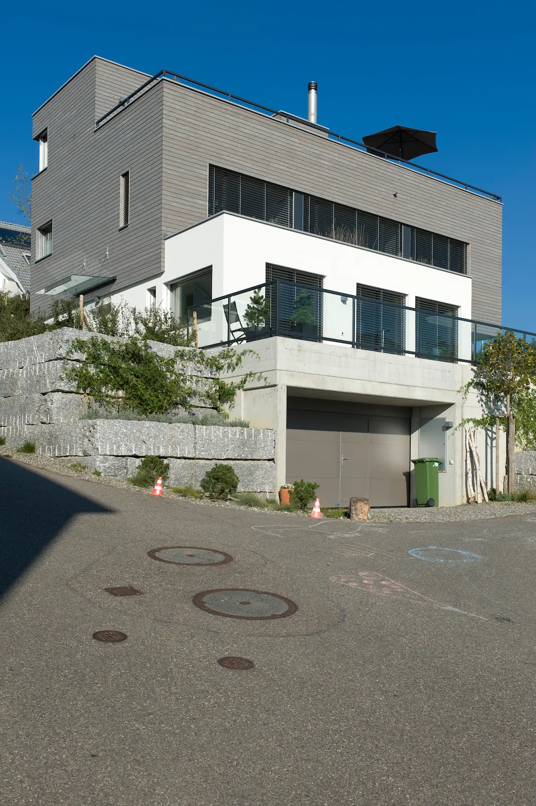 Strassenansicht Neubau Einfamilienhaus in Untersiggenthal mit Holzelementbau, Garage im Sockelgeschoss und Holzfassade in horizontaler Ausführung