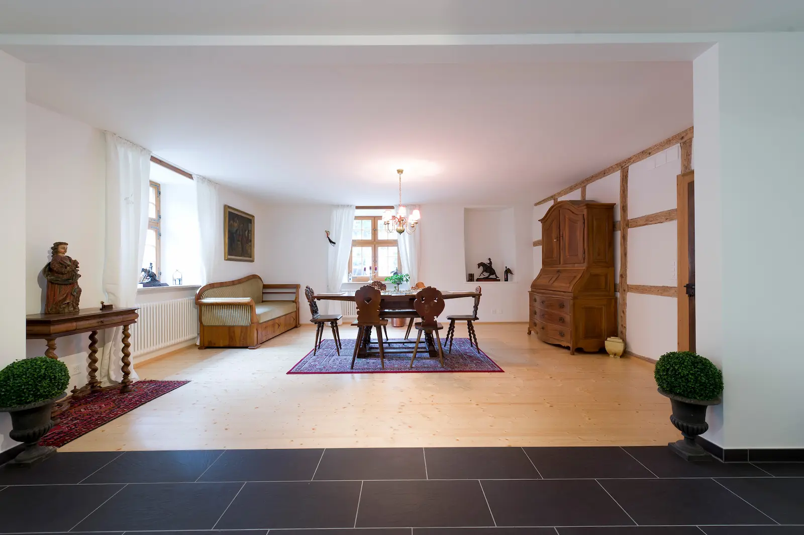 Esszimmer im Schloss Hilfikon mit Holzboden, Fachwerkwand und historischer Möblierung