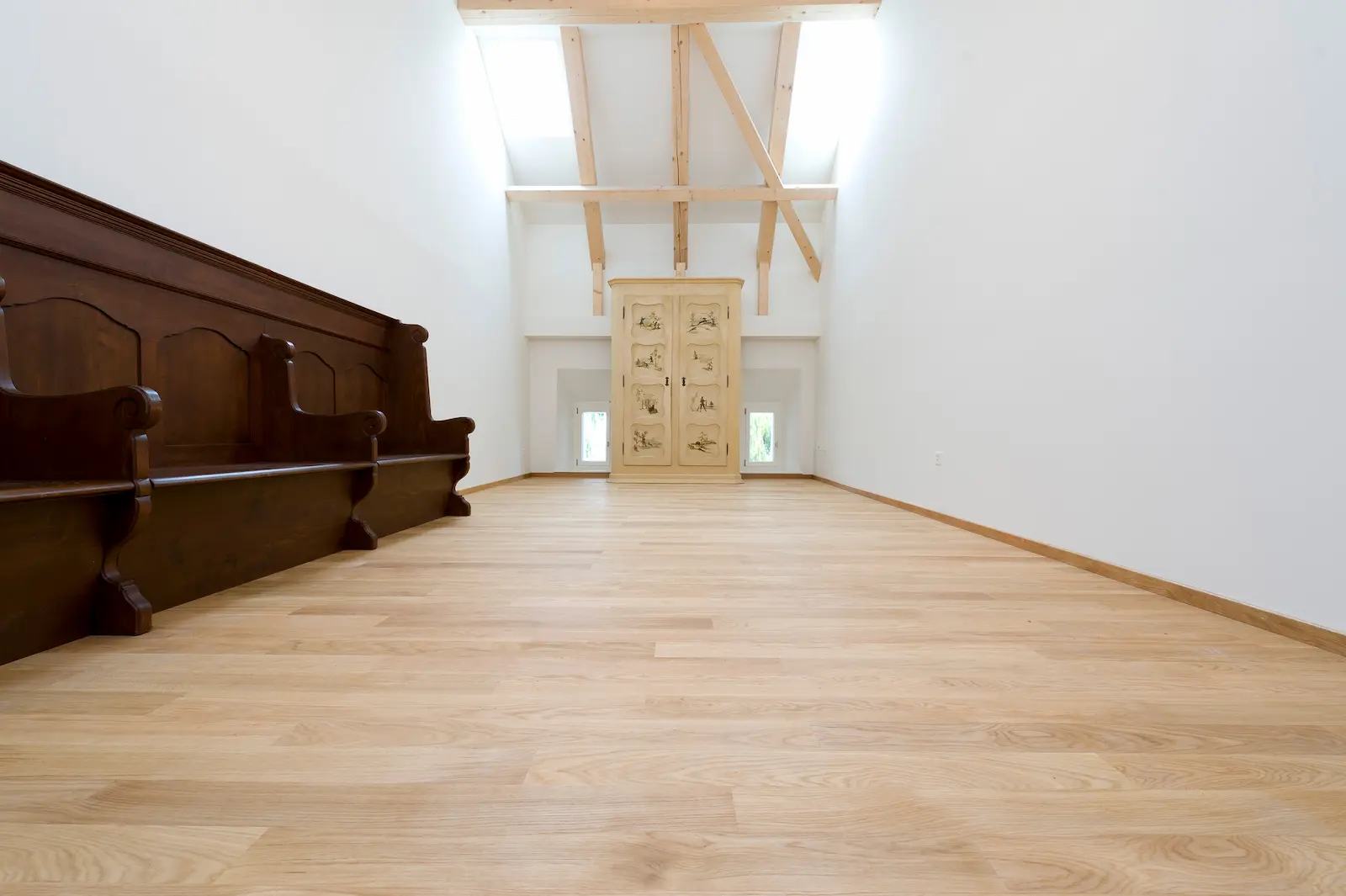 Wohnraum im Schloss Hilfikon mit saniertem Holzboden, zentralem Tisch und Stuckdecke