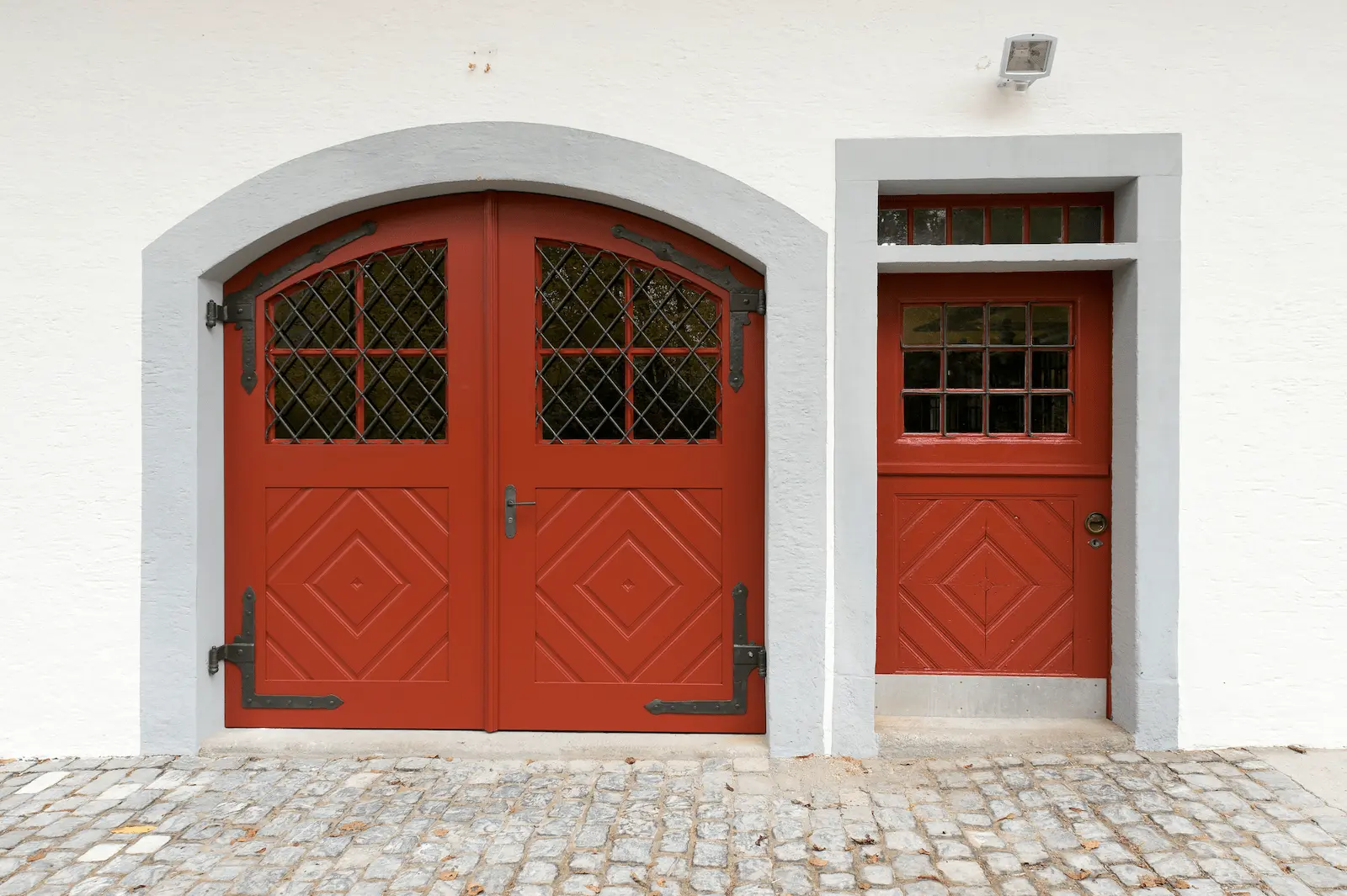 Restauriertes historisches Tor mit roter Holztür und schmiedeeisernen Beschlägen im Schloss Hilfikon