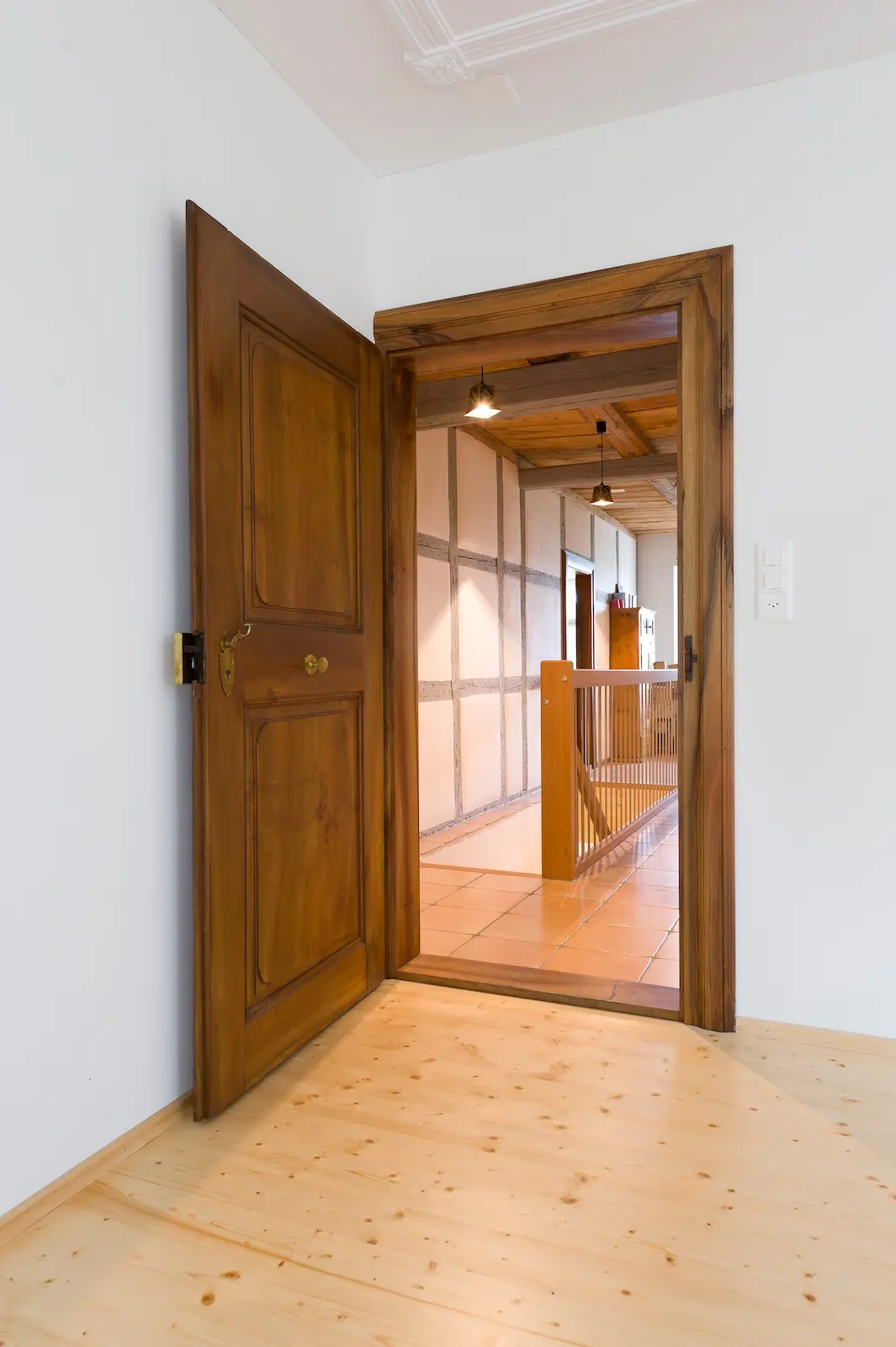 Geöffnete restaurierte Holztür im Schloss Hilfikon mit Blick auf den Wohnbereich und Fachwerkwand