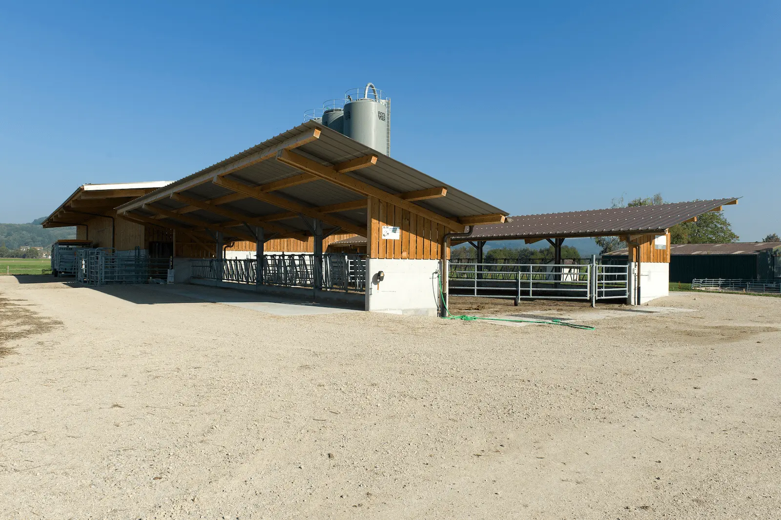 Aussenansicht des modernen Kuhstalls in Rietheim mit grosszügiger Überdachung und Holzbauweise.