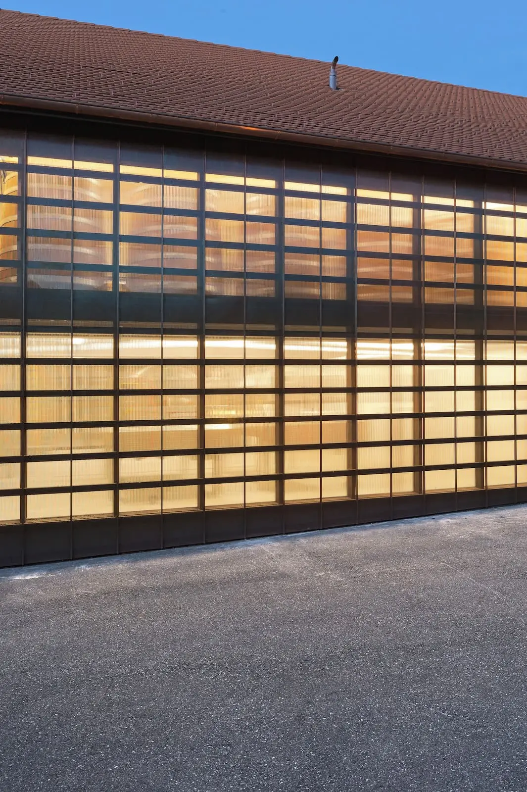 Holzelementbau Weingut Würenlingen mit beleuchteter Holzfassade und durchscheinenden Elementen