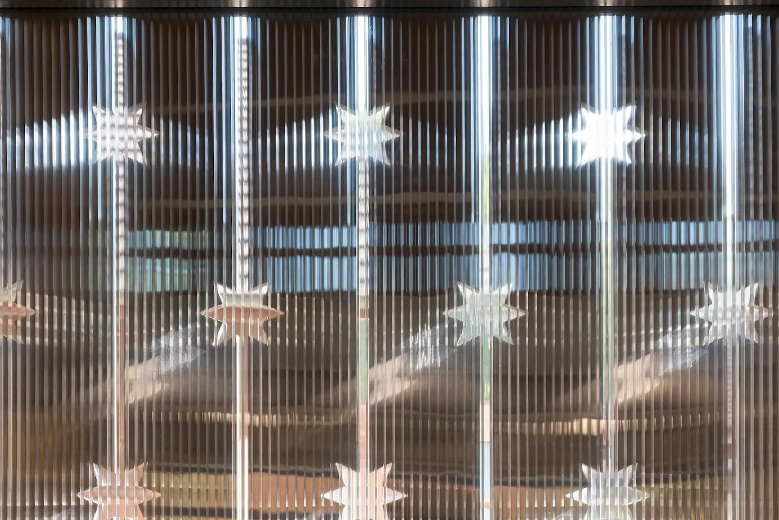 Detailansicht der Holzfassade mit sternförmigen Gravuren am Weingut Würenlingen