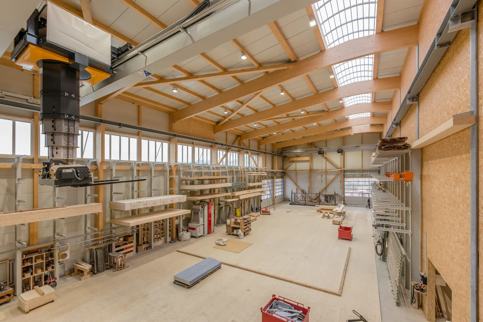Innenansicht der Produktionshalle in Kleindöttingen mit Holztragwerk und Krananlage
