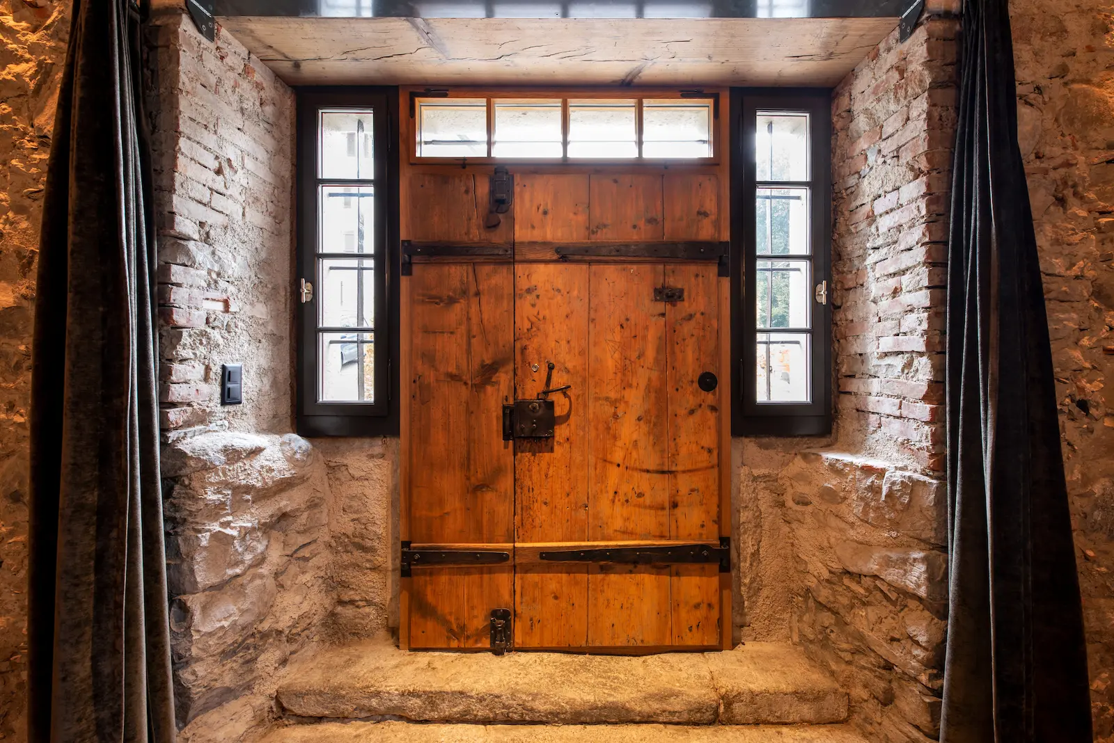 Historische Holztür am Haupteingang der Mühle Seon mit Natursteinrahmen