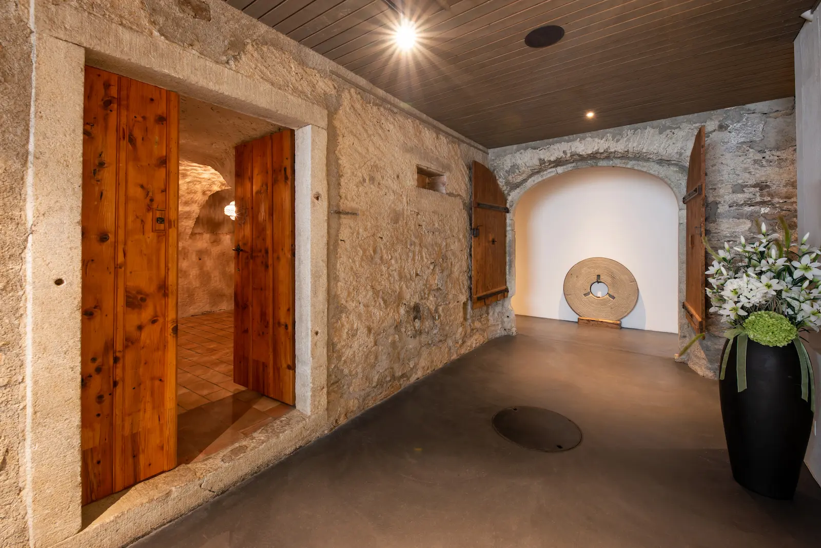 Innenraum der Mühle Seon mit historischen Holztoren und Natursteinmauer