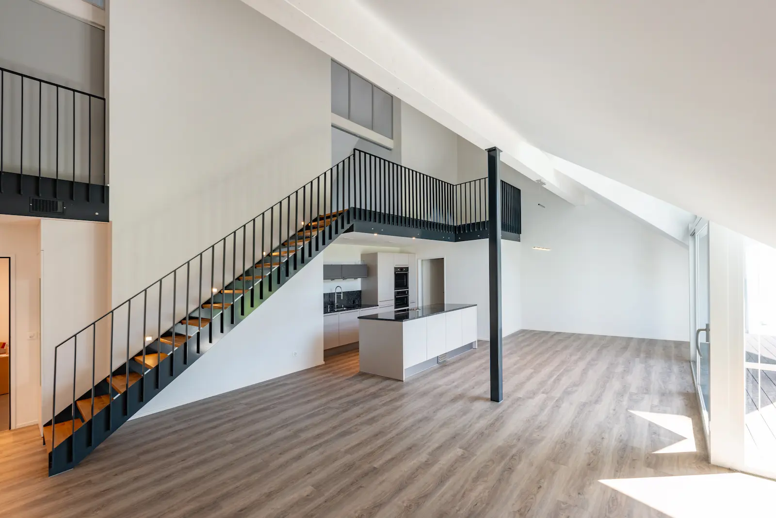 Wohnraum mit offener Küche und Treppe aus Stahl und Holz im Mehrfamilienhaus Gansingen