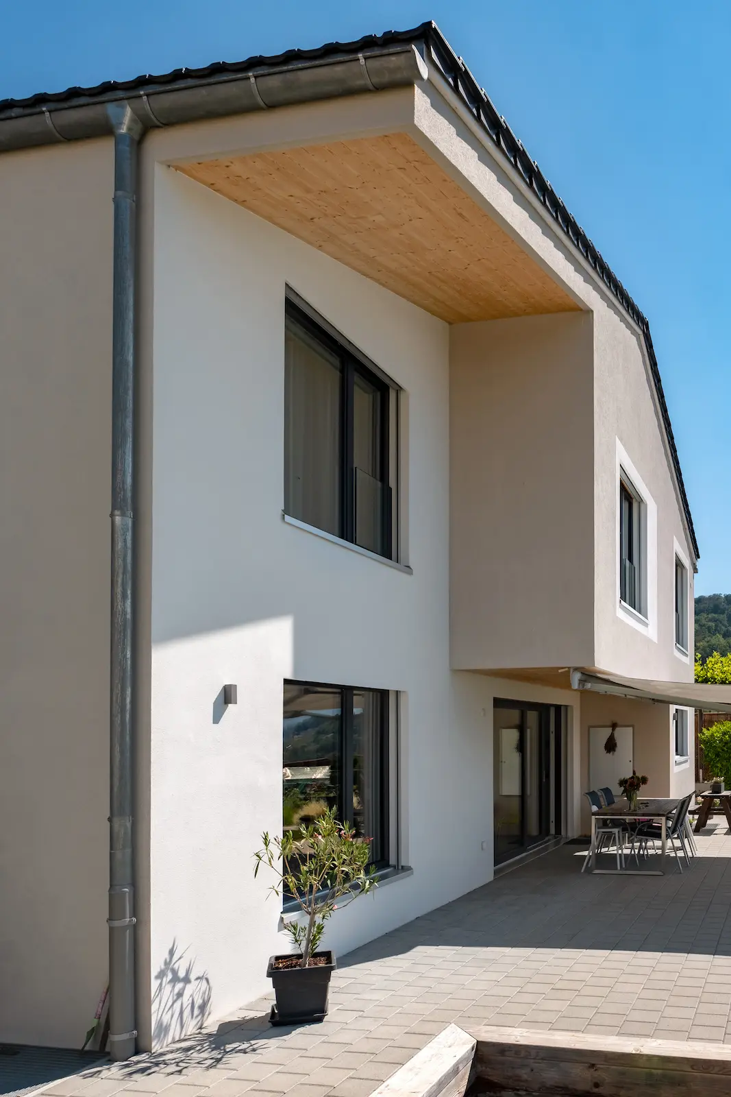 Detail moderner Holzbauarchitektur mit sichtbarer Dreischichtplatte und grossen Fenstern am Einfamilienhaus in Holzelementbauweise.