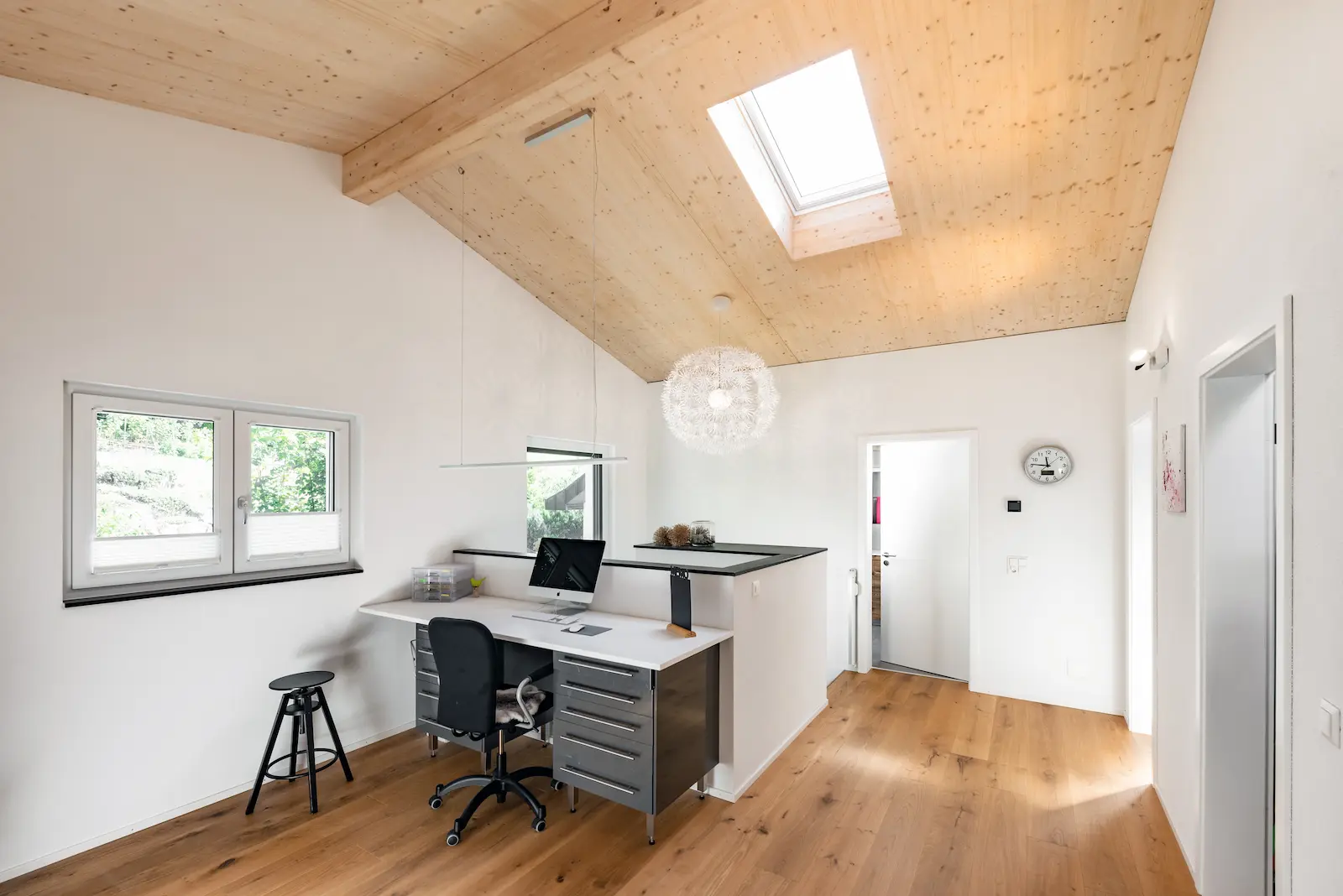 Heller Arbeitsbereich mit Dachfenster, Massivholzboden und Holzdecke – modernes Innenraumkonzept im Einfamilienhaus Klingnau.