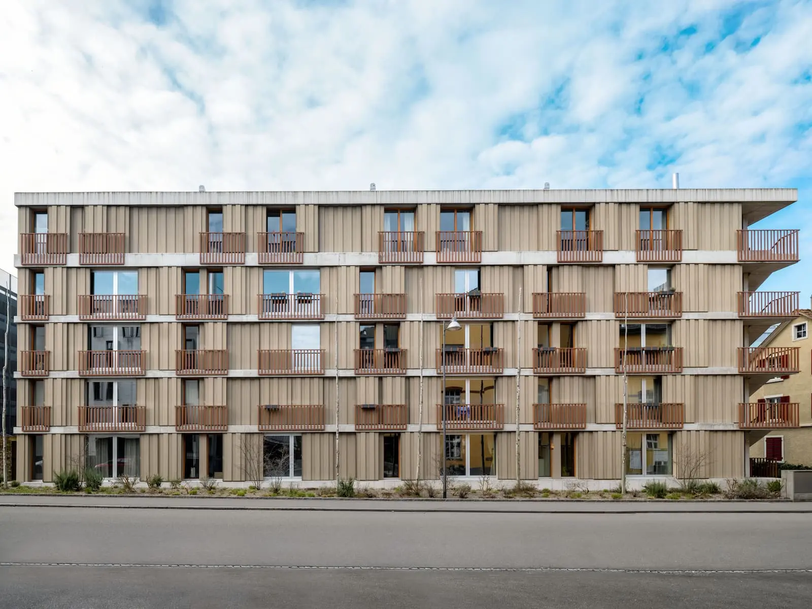 Mehrfamilienhaus mit strukturierter Holzfassade aus Schweizer Holz – nachhaltige Bauweise im städtischen Kontext von Baden.