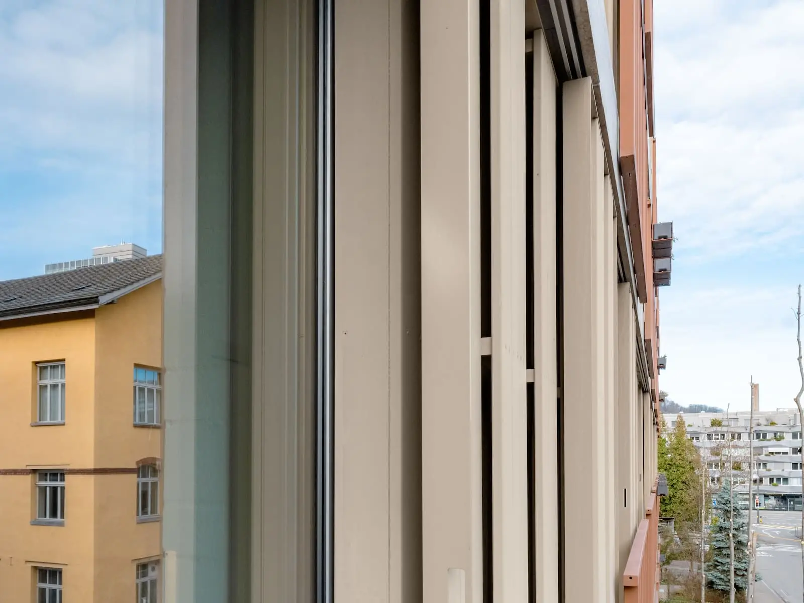 Vertikale Lamellenstruktur der Holzfassade mit Fensterausschnitt – klare Linienführung und gestalterische Tiefe