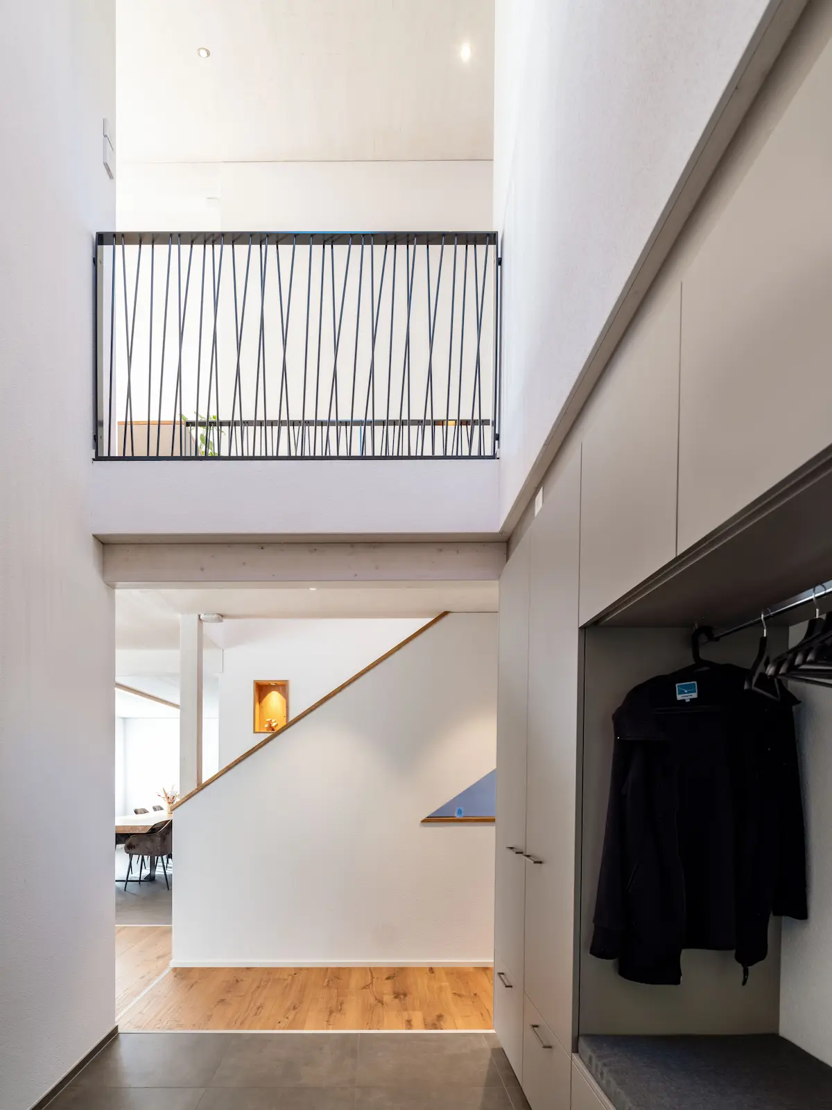 Eingangsbereich im Erdgeschoss mit verputzten Wänden und Garderobe im Holzelementbau