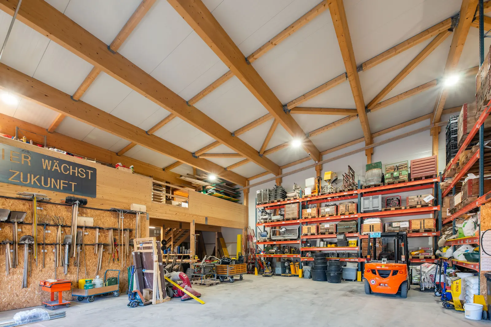 Innenansicht der Industriehalle mit sichtbarem Holztragwerk und Lagerregalen