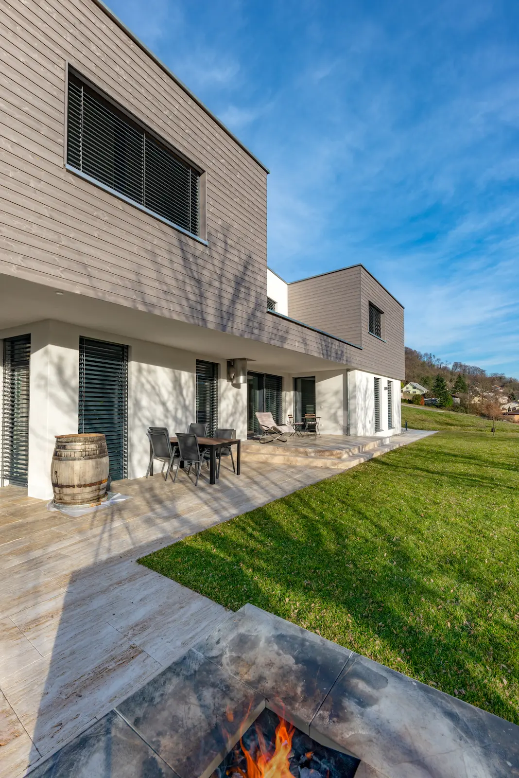Gartenansicht Einfamilienhaus Mettau mit Holzfassade und vorgelagerter Terrasse