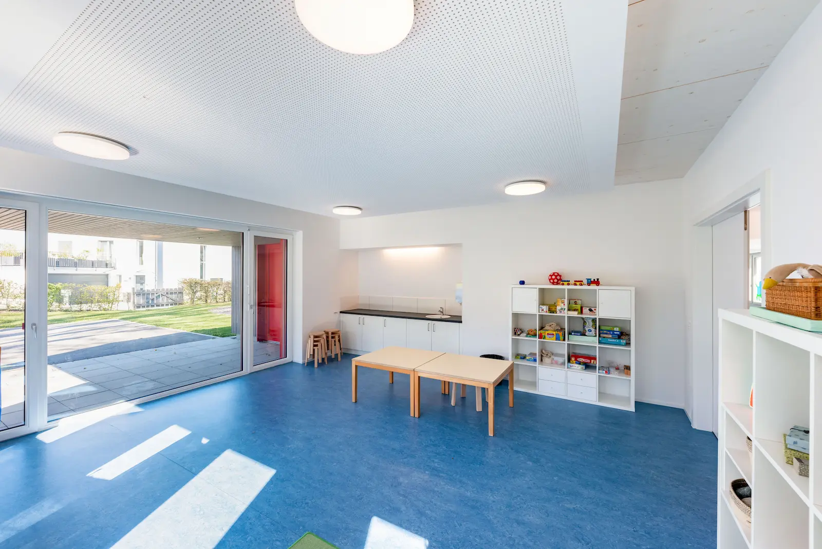 Gruppenraum mit grossen Glasfronten und Zugang zum Aussenbereich