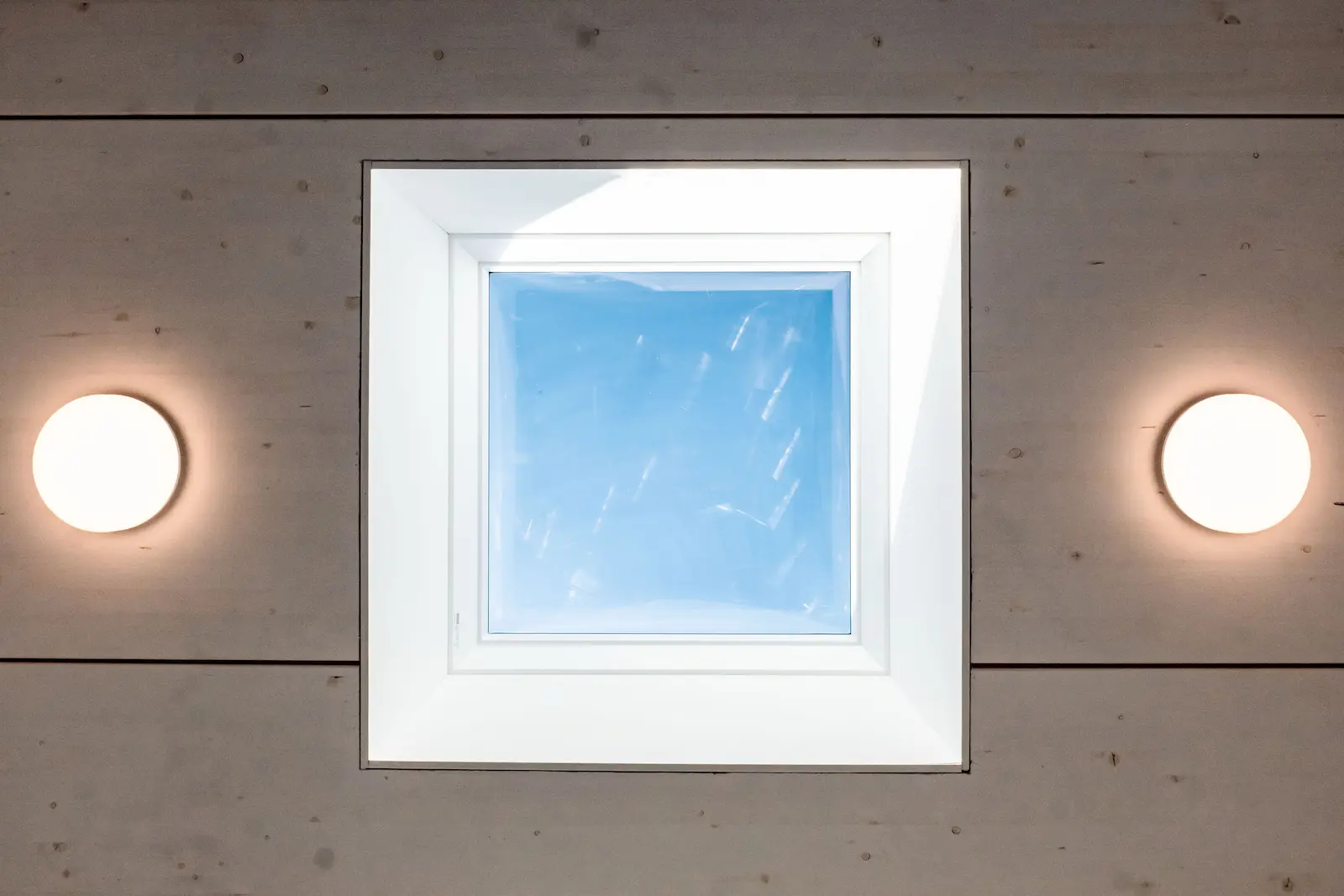 Detailansicht Dachfenster mit Blick in den Himmel.