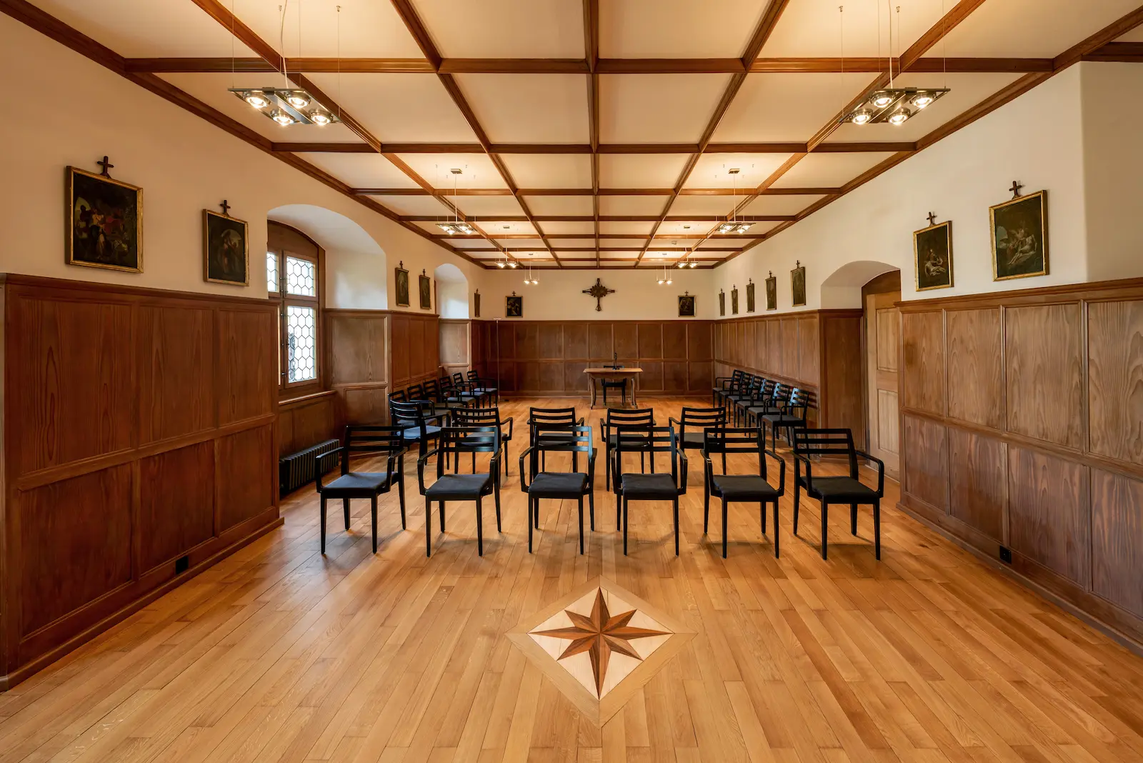 Versammlungsraum Kloster Fahr mit saniertem Riemenboden, Intarsienmotiv und Holzvertäfelung an den Wänden