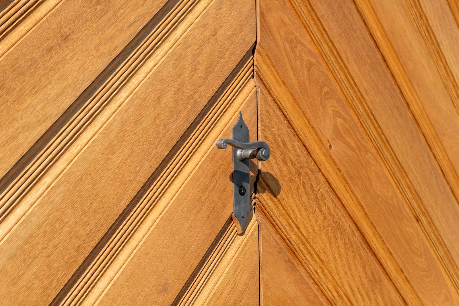Detailaufnahme einer sanierten Holztüre im Kloster Fahr mit dekorativer Maserung und historischem Türgriff.
