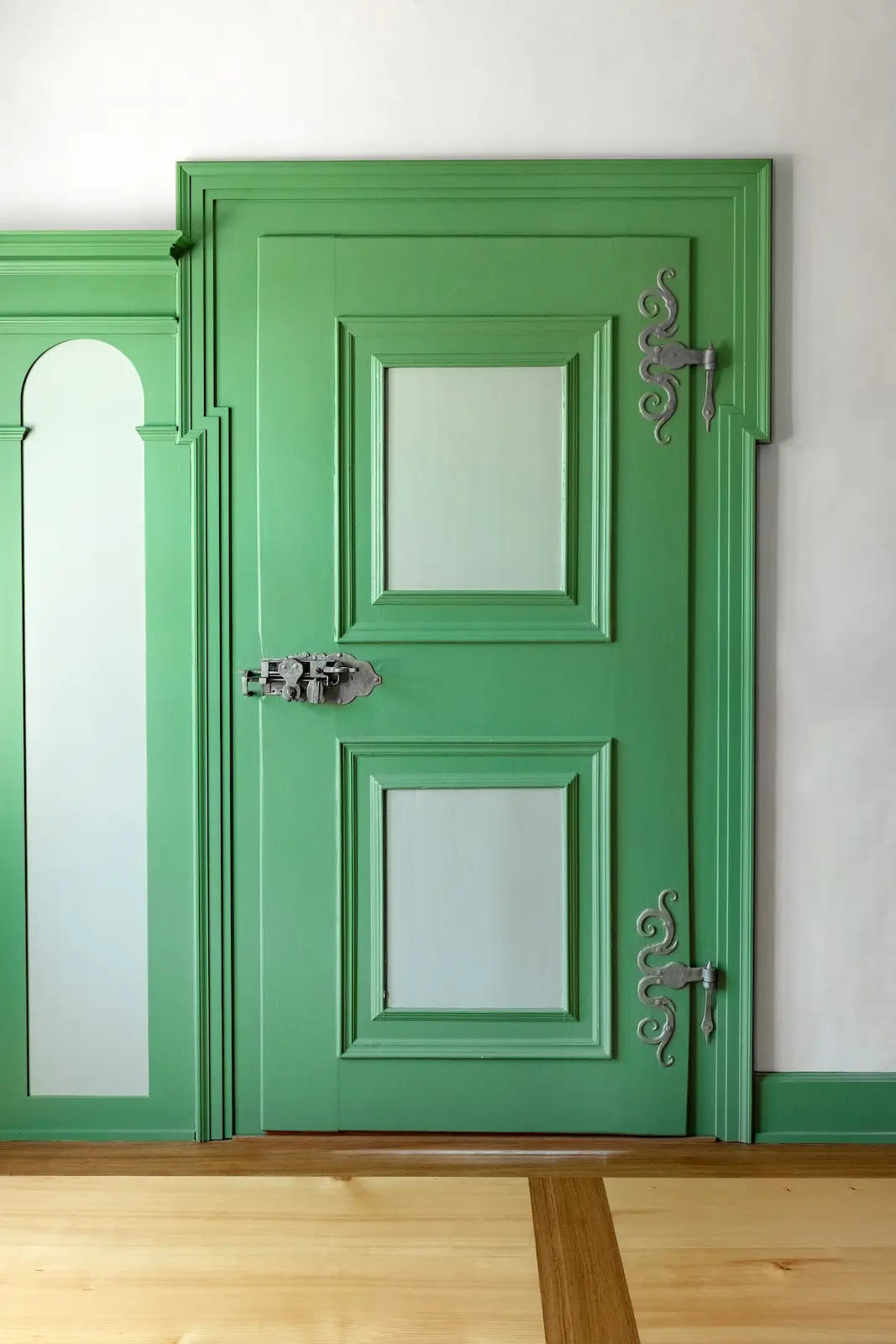 Grün gestrichene historische Zimmertüre im Kloster Fahr mit kunstvoll geschmiedeten Eisenbeschlägen.