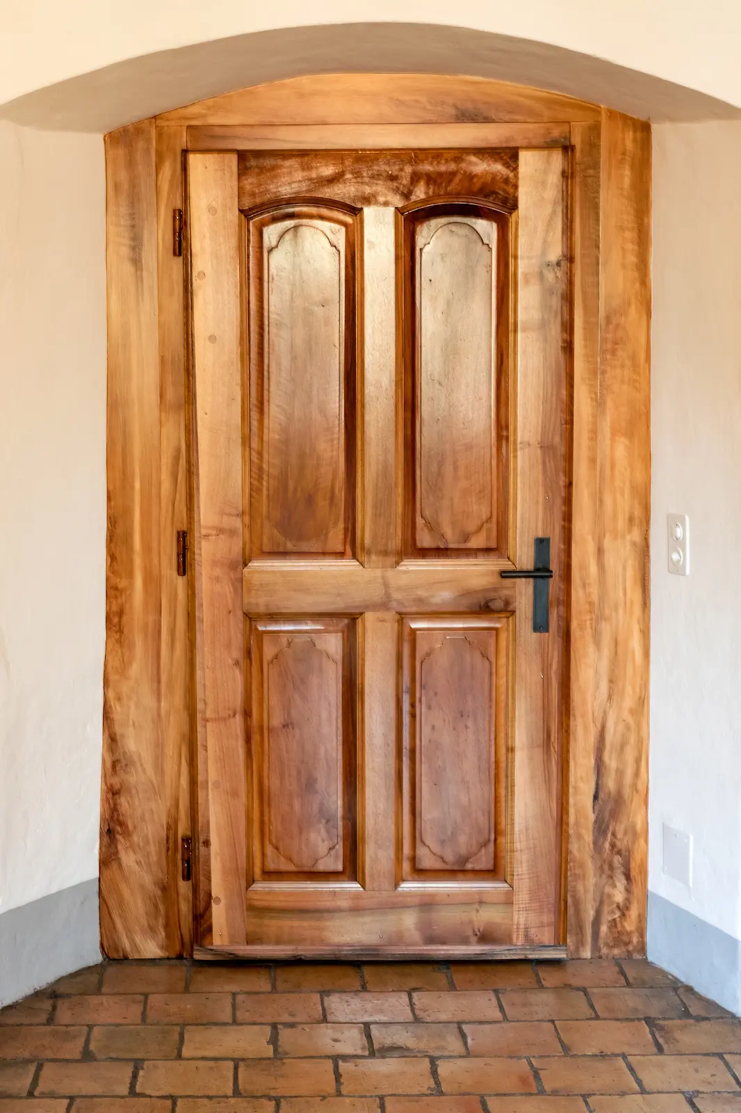 Restaurierte massive Holztüre im Innenbereich des Klosters Fahr, mit charakteristischen Füllungen und Holzmaserung.