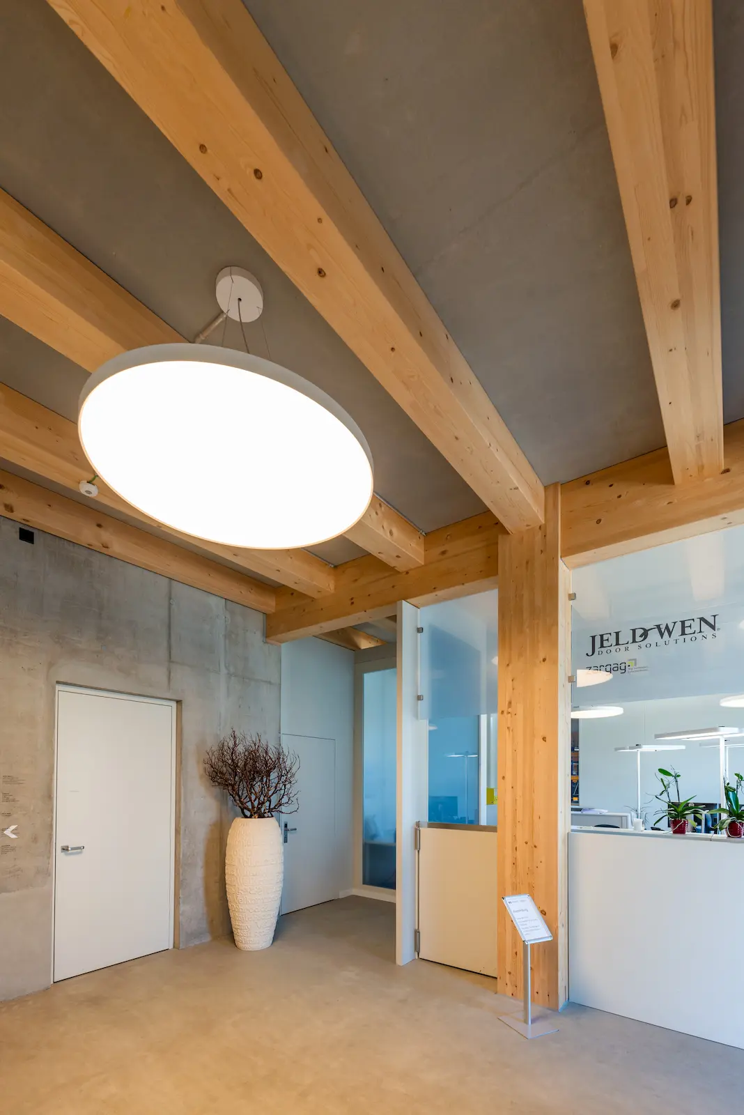 Bürobereich mit sichtbarem Holztragwerk und Betonelementen