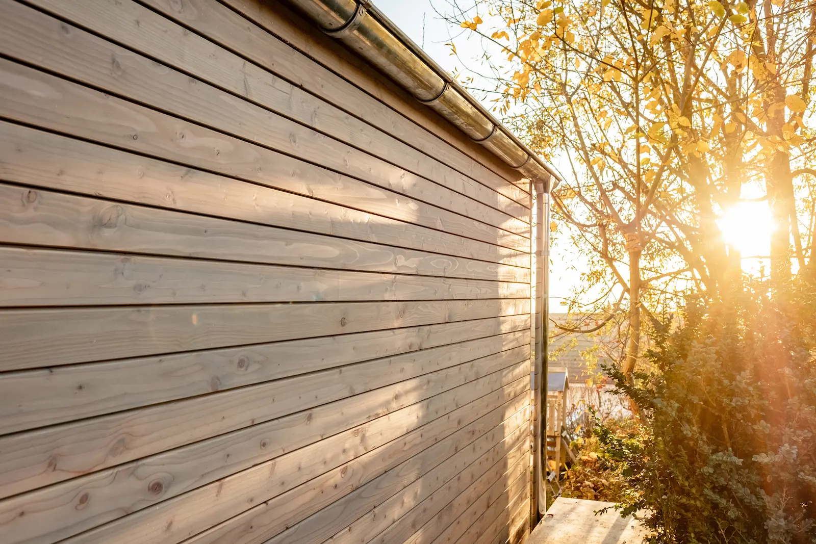 Aussenansicht der Holzfassade des Unterstands im Sonnenlicht.