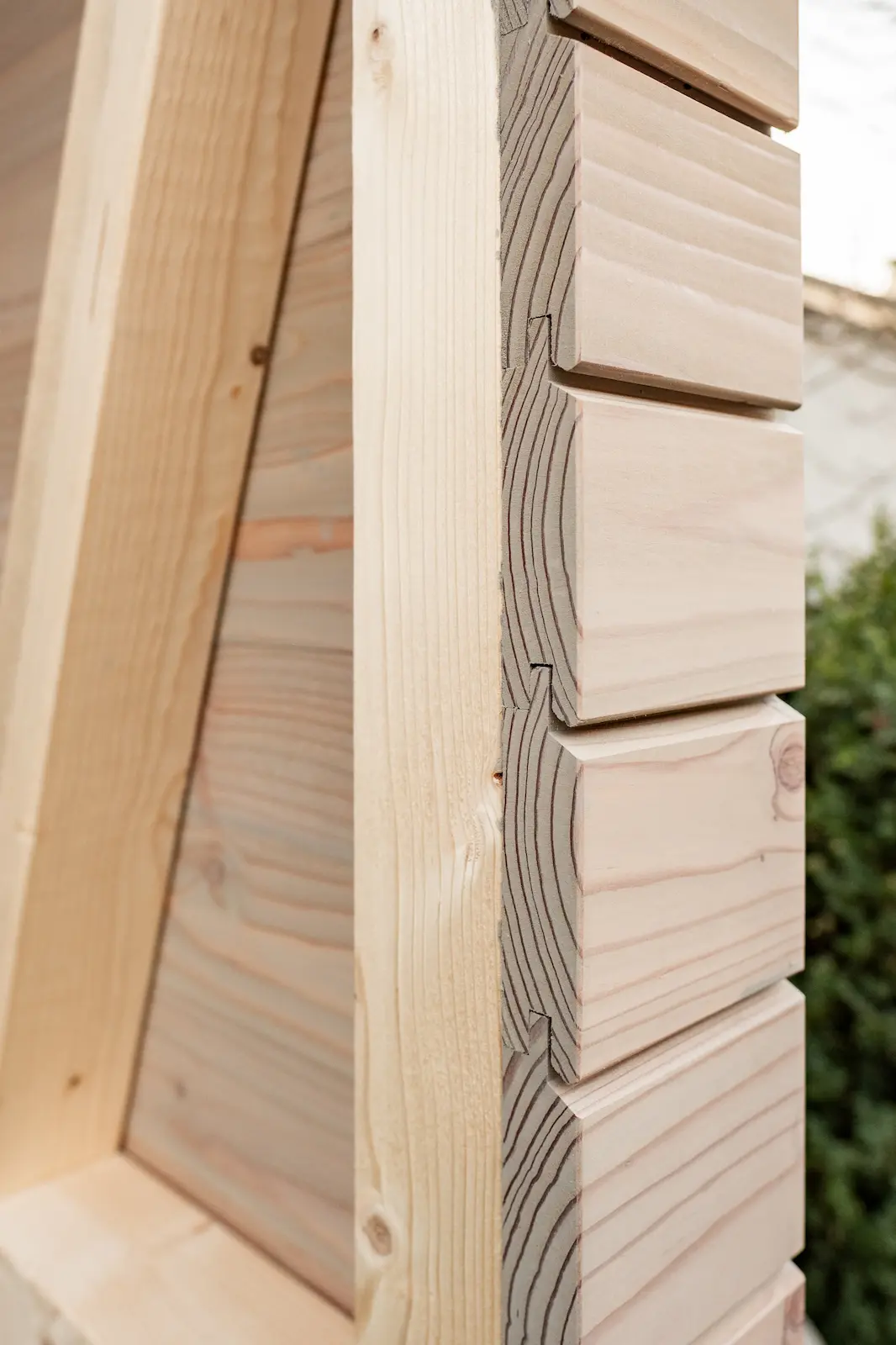 Eckansicht der vorvergrauten Holzfassade mit sichtbarer Schichtung.