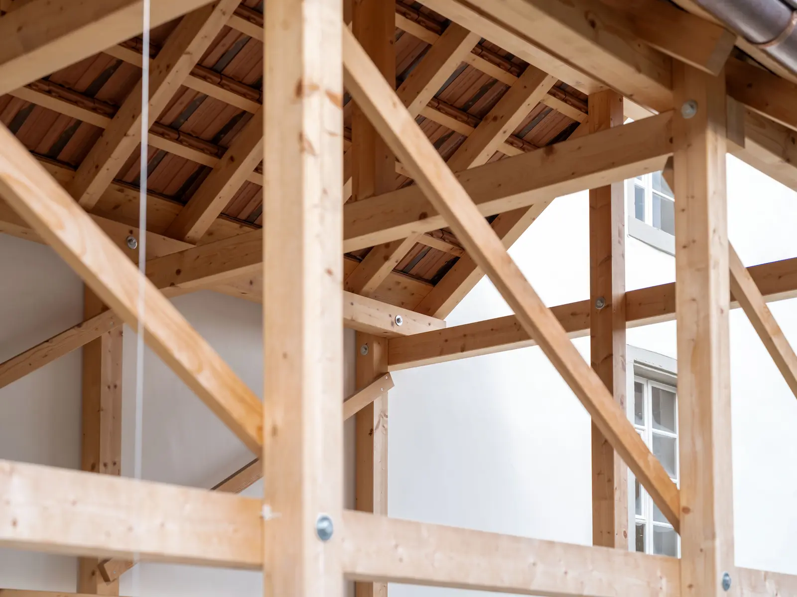 Tragwerk im Dachbereich mit Holzverbindungen und sichtbaren Verschraubungen