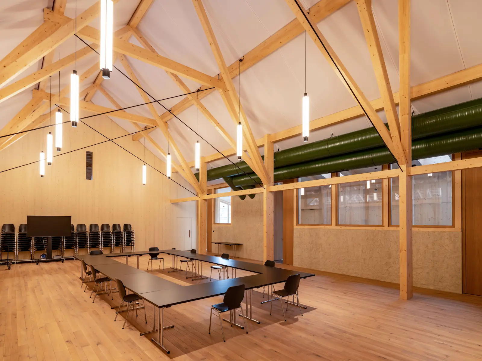 Grosser Saal mit Holztragwerk und Deckenbeleuchtung
