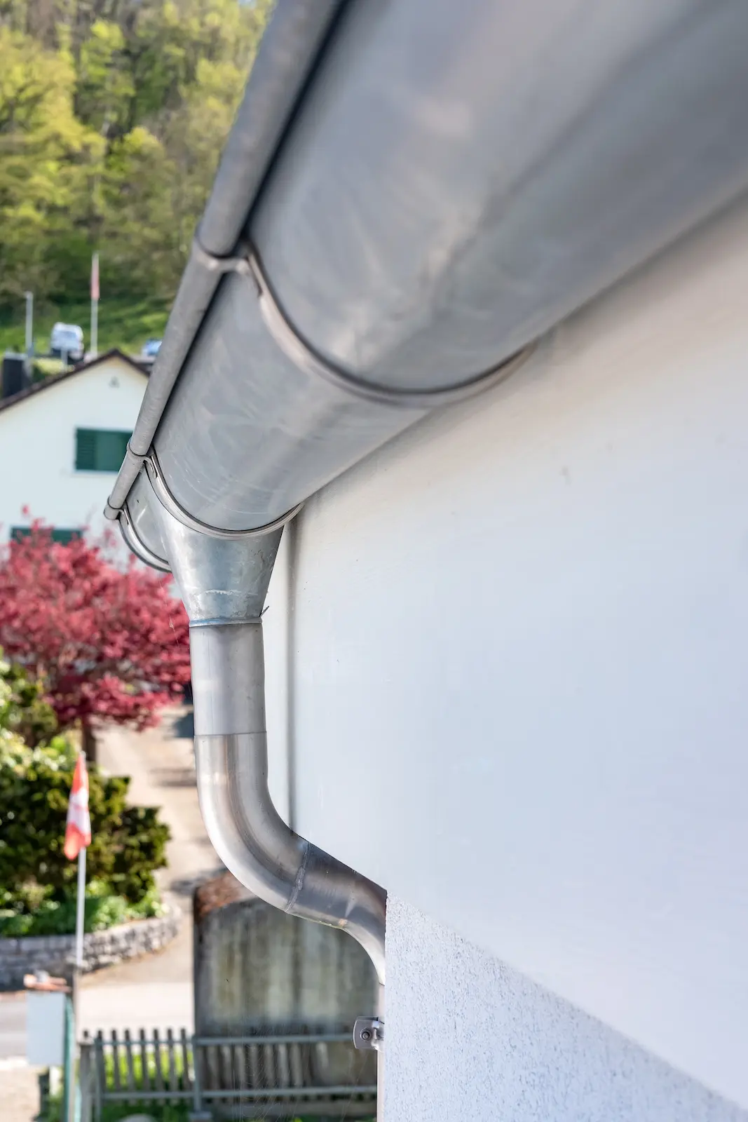 Detailansicht einer metallenen Dachrinne mit Halterung am Scheunenanbau in Klingnau.