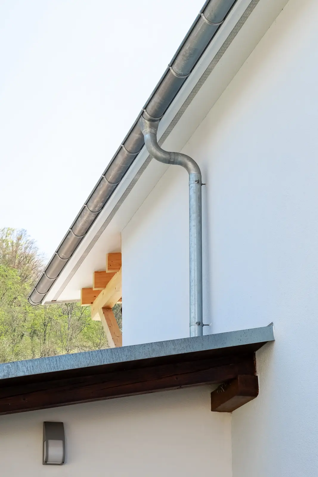 Metallene Dachrinne mit angeschlossenem Fallrohr an der Fassade des Scheunenanbaus in Klingnau.