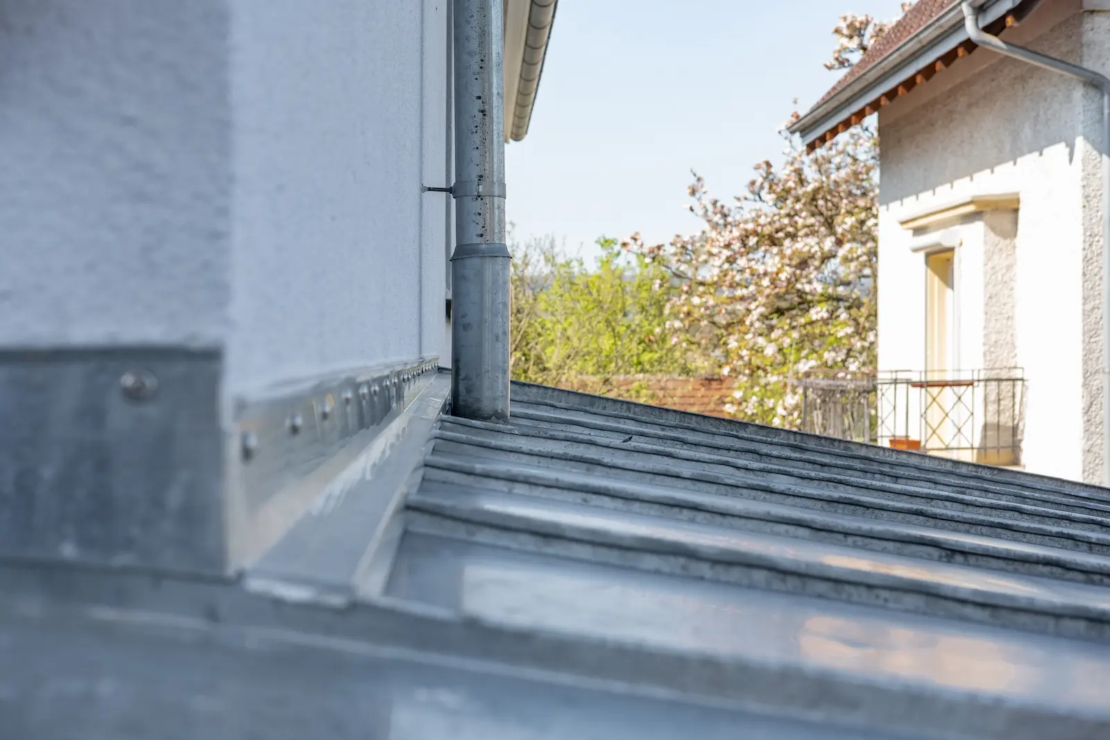 Anschlussbereich von Falzbahnen und Wandanschlussblech mit Regenfallrohr am Anbau in Klingnau.