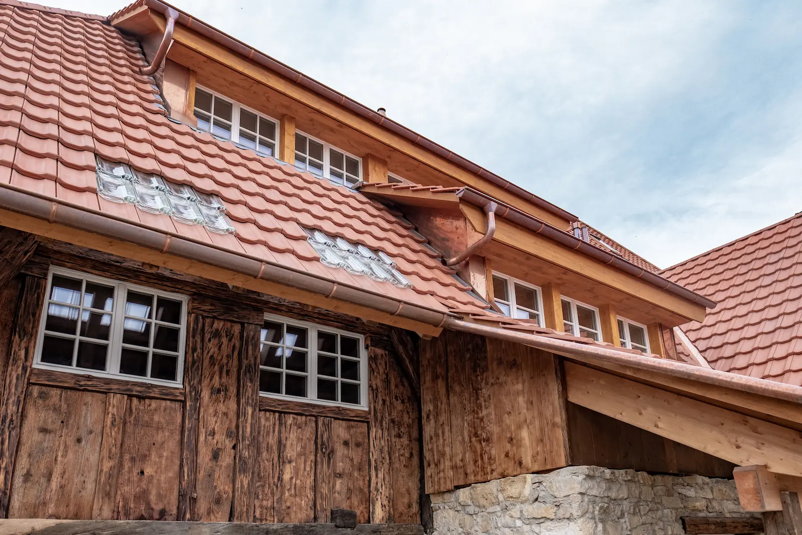 Detailaufnahme der neuen Dacheindeckung mit Ziegeln und Kupferrinnen