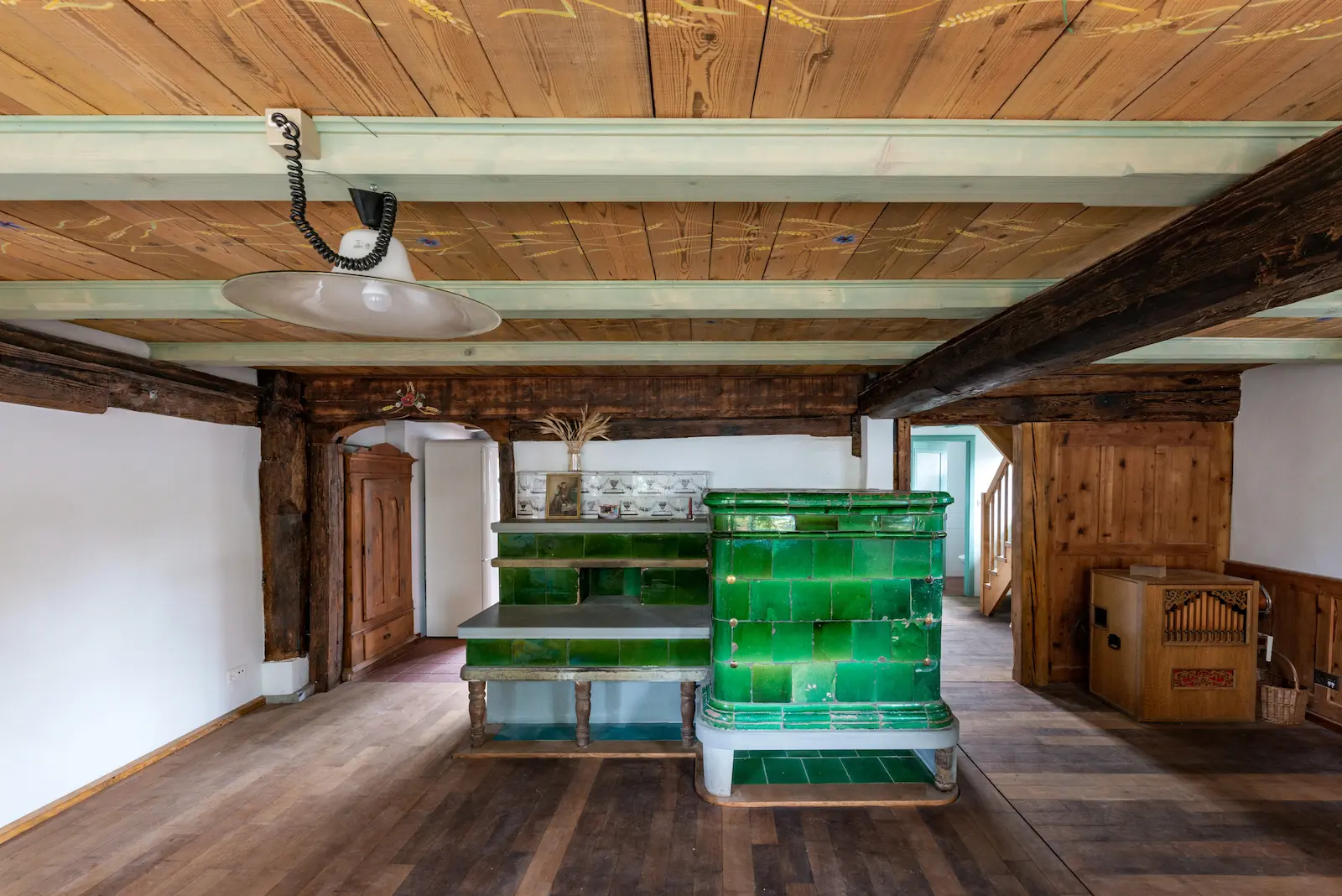 Stube mit restauriertem Kachelofen, Holzboden und Deckenmalerei im Dalihaus