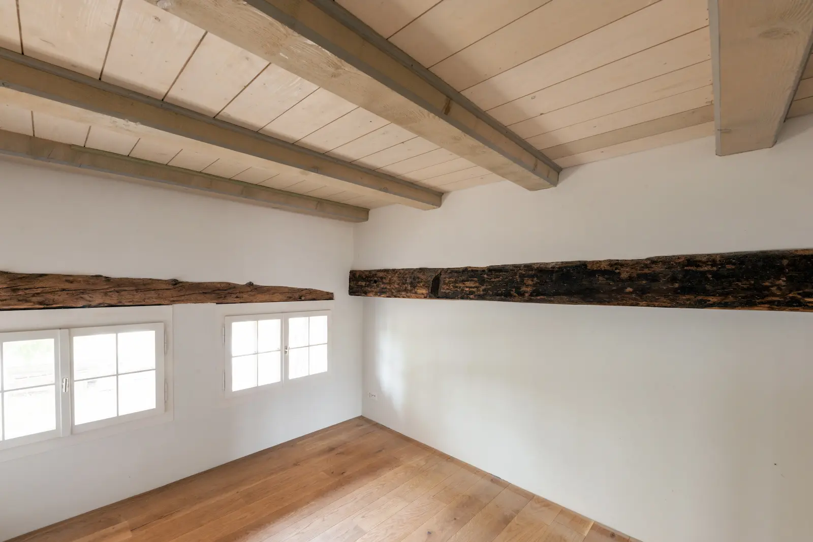 Detailaufnahme eines historischen Holzbalkens mit handwerklicher Zapfenverbindung im Dahlihaus Hausen.